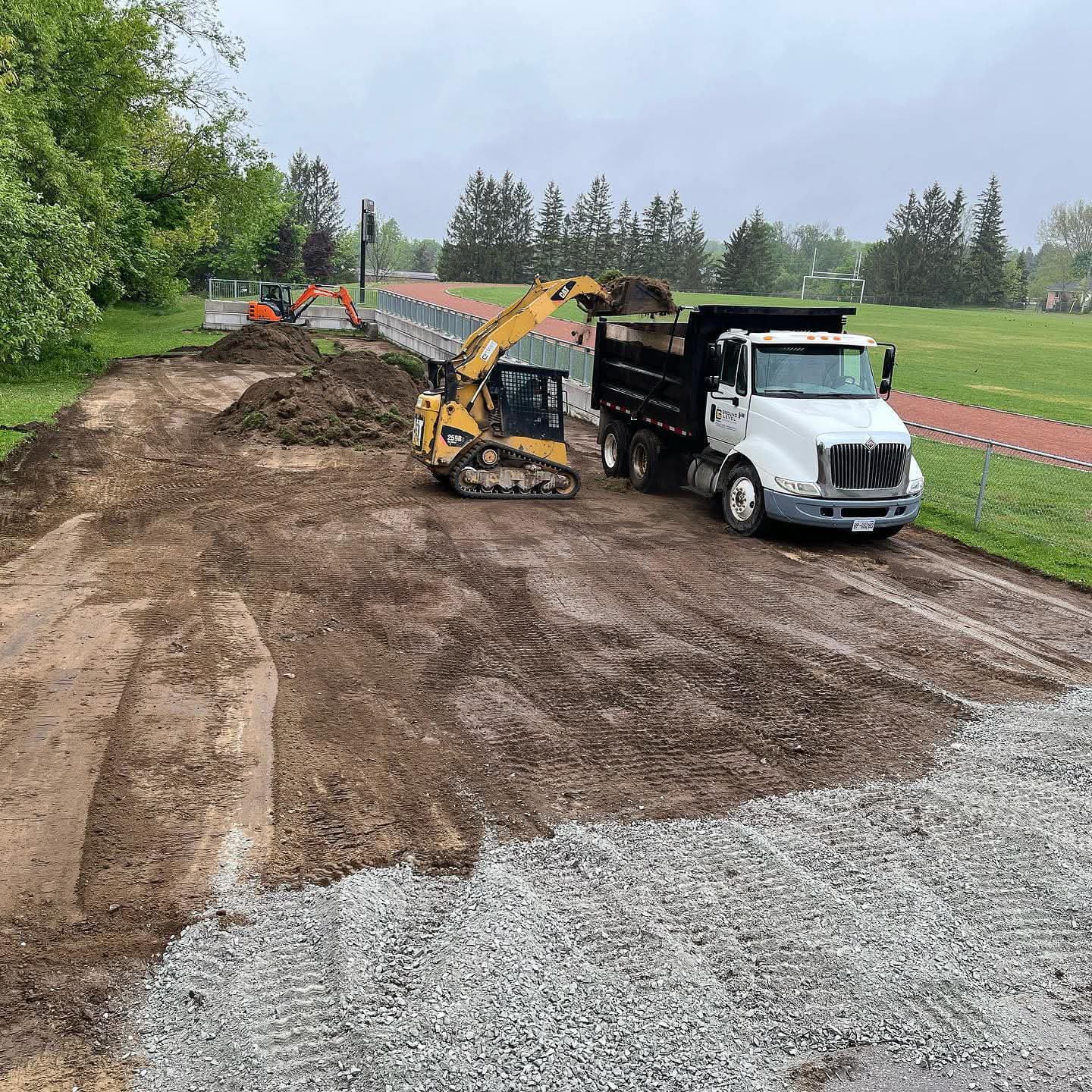 Commercial hauling and earthmoving equipment staged for site logistics and material movement in Simcoe County