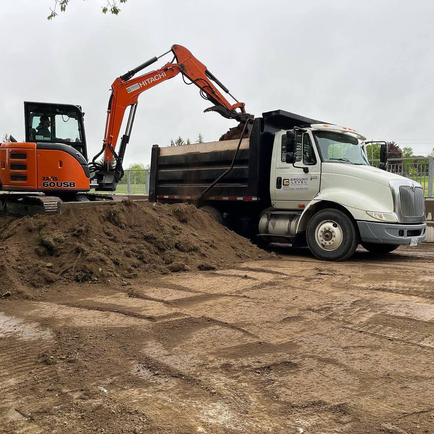 Heavy equipment performing professional site grading and hauling on a commercial construction site in Barrie Ontario