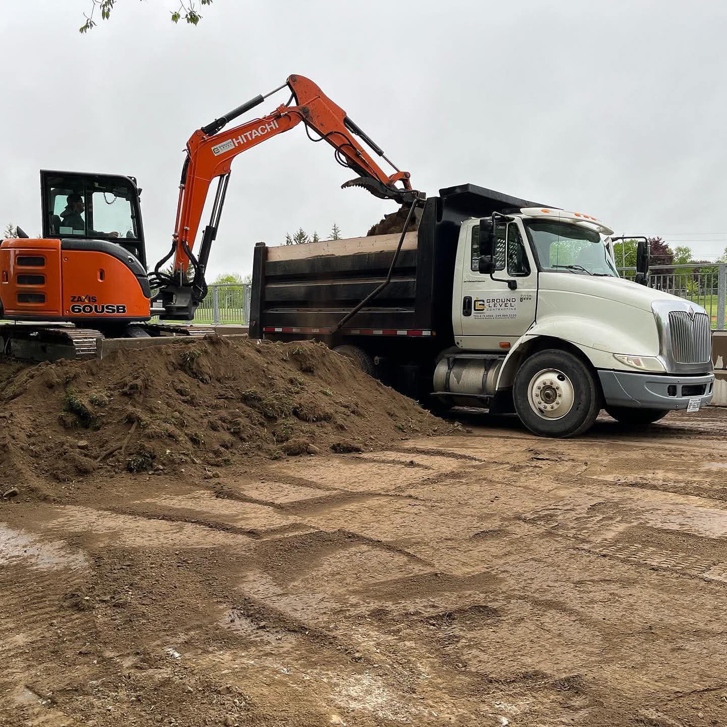 Heavy equipment performing professional site grading and hauling on a commercial construction site in Barrie Ontario